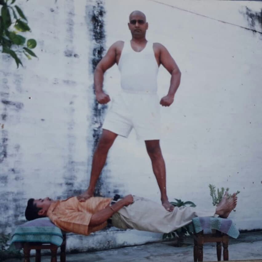 Demonstration of hypnotism technique from 'Sammohan Se Yog Nidra Ek Vigyan' showing a man standing on another lying on chairs.