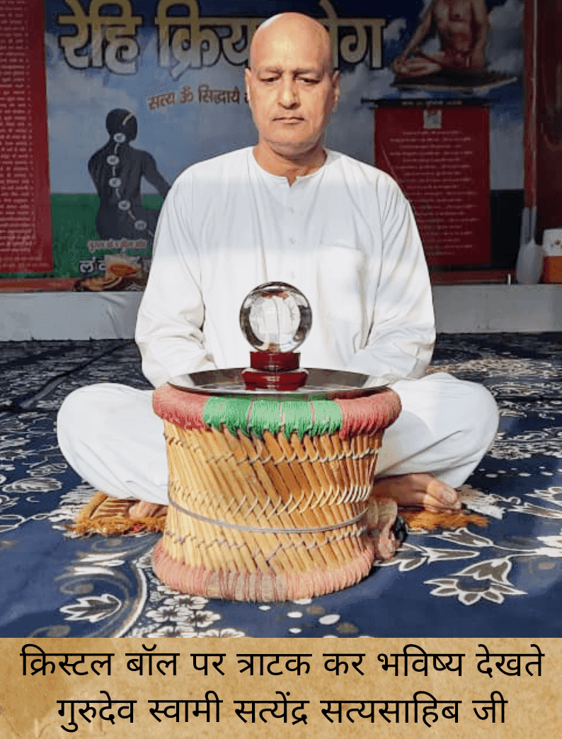 A man in white attire sits cross-legged on a mat with a crystal ball placed on a woven stool, symbolizing meditation and future insights.